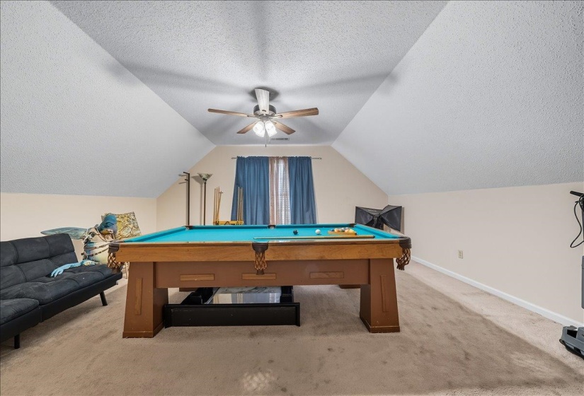 Recreation room with a textured ceiling, carpet, pool table, and ceiling fan