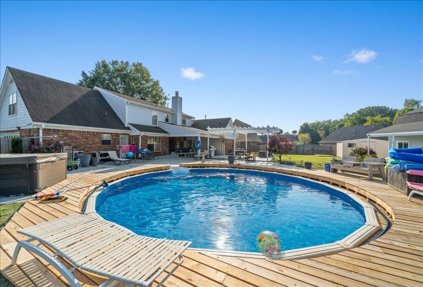 View of pool with patio surround, a hot tub, and a deck