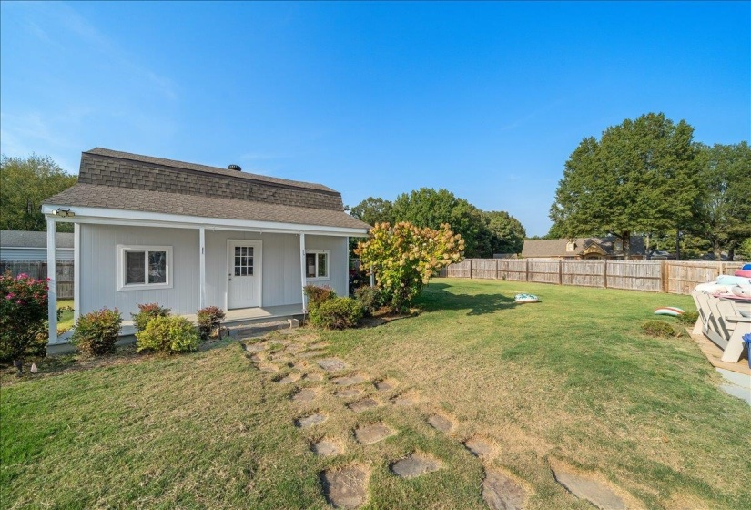 Rear view of house featuring a shingled roof and covered porch