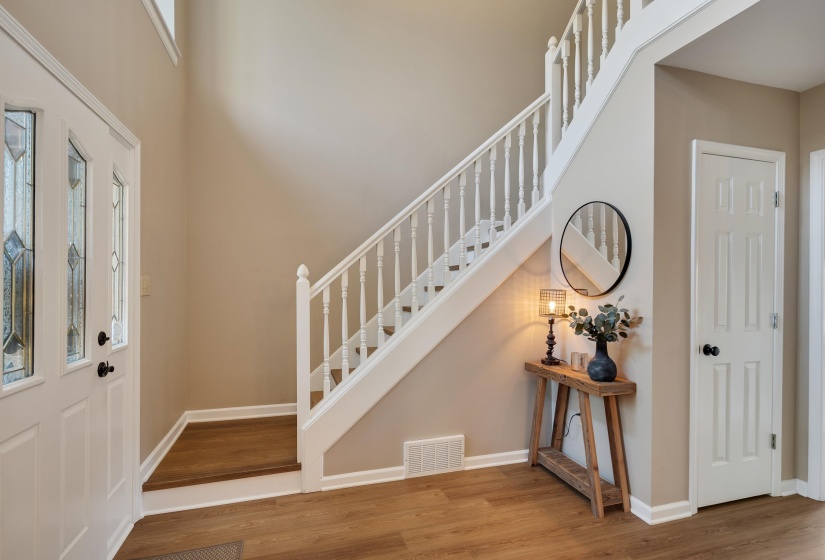 Entryway with light wood-type flooring and a high ceiling