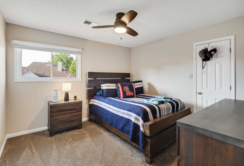 Carpeted bedroom with ceiling fan and baseboards