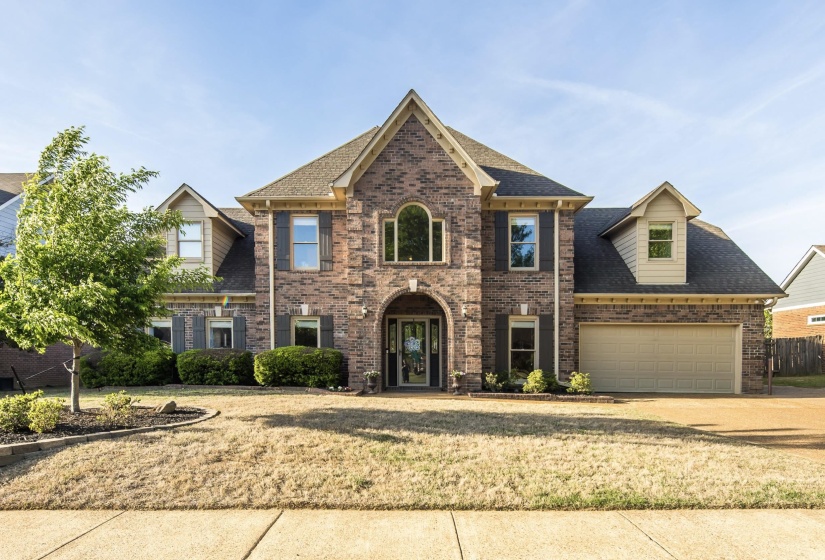 View of front facade with an attached garage, concrete driveway, brick siding, and roof with shingles