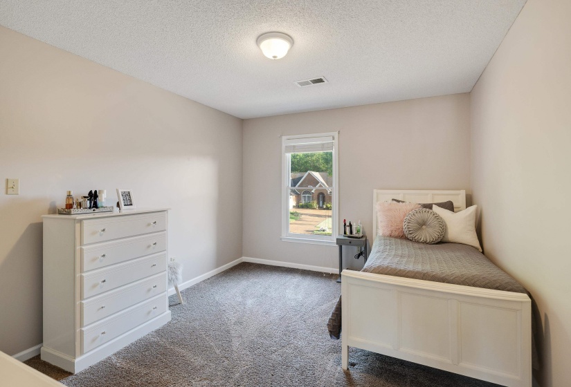 Bedroom featuring light colored carpet and a textured ceiling