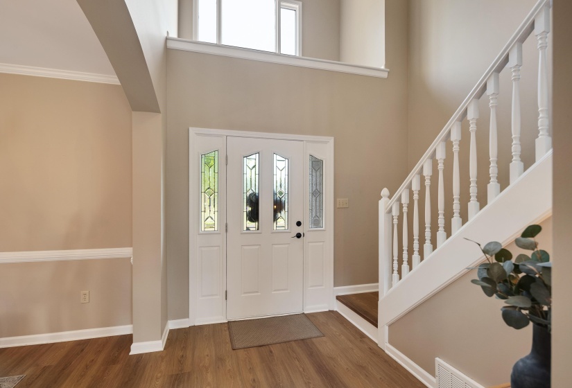 Foyer entrance with dark wood finished floors, a high ceiling, and ornamental molding