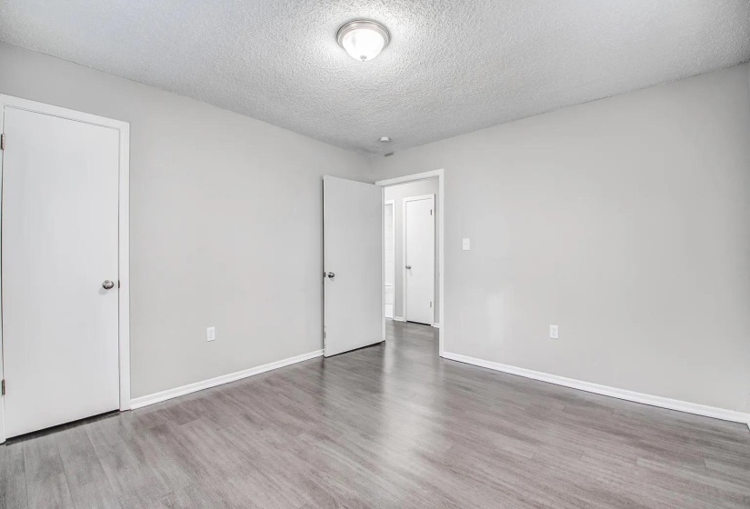Unfurnished bedroom with a textured ceiling and light wood-style floors