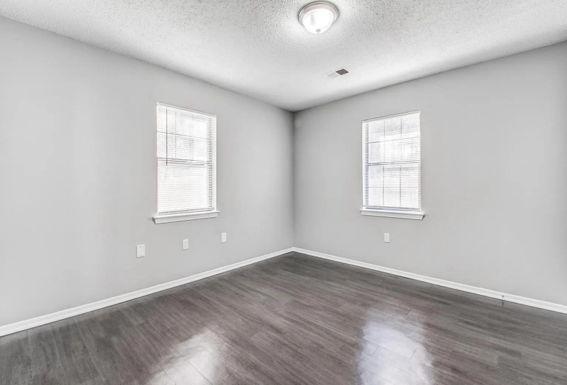 Spare room featuring a textured ceiling and dark wood-style floors