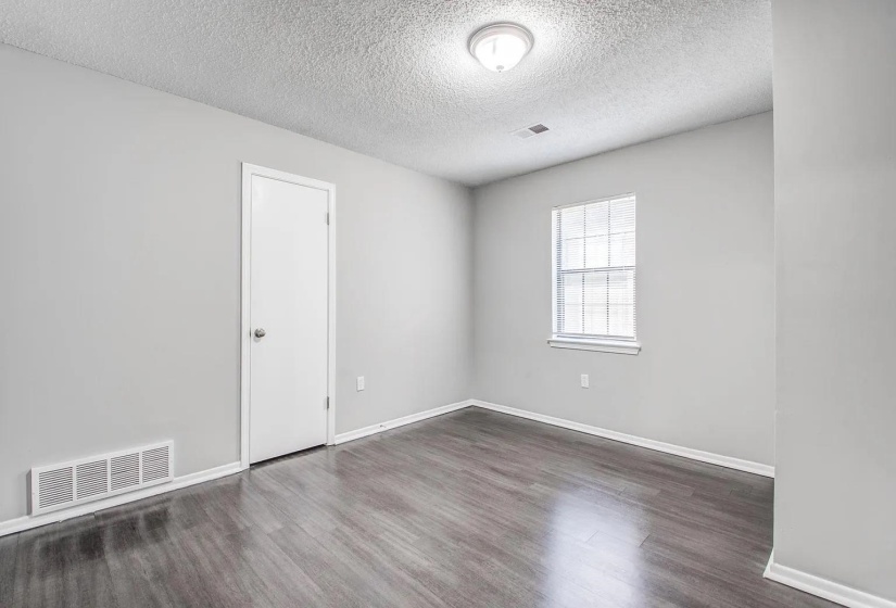 Unfurnished room with a textured ceiling and dark wood finished floors