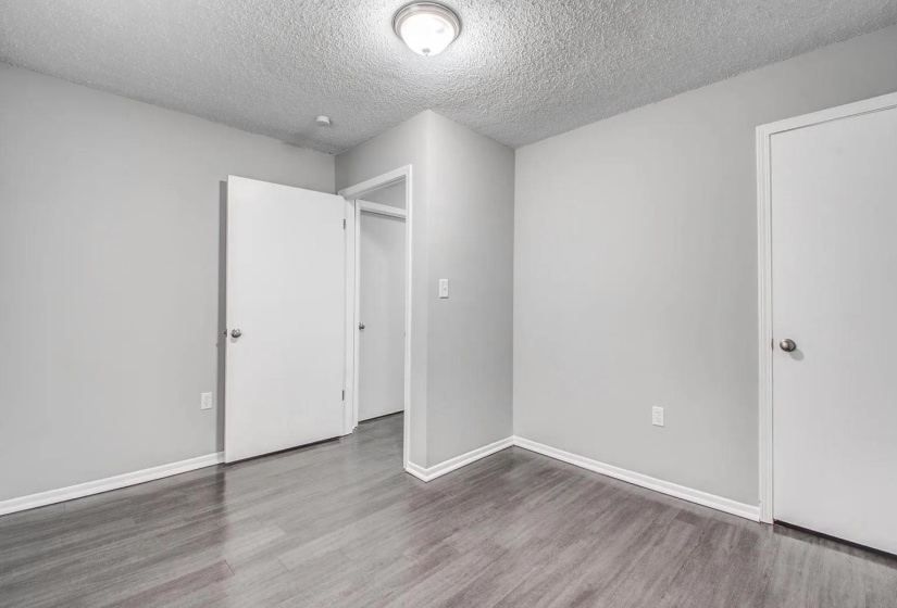 Unfurnished bedroom featuring a textured ceiling and wood finished floors