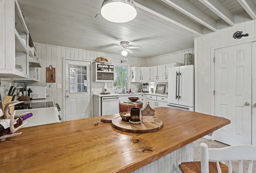 Dining area with wooden walls, wood ceiling, and ceiling fan