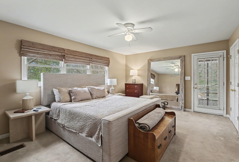 Bedroom with light colored carpet, multiple windows, access to exterior, and a ceiling fan