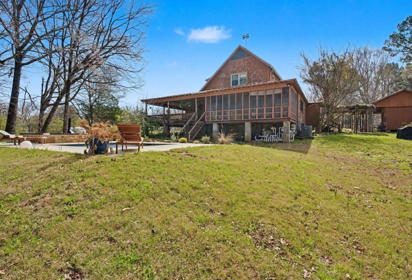 Back of house featuring a yard, a patio, and a sunroom
