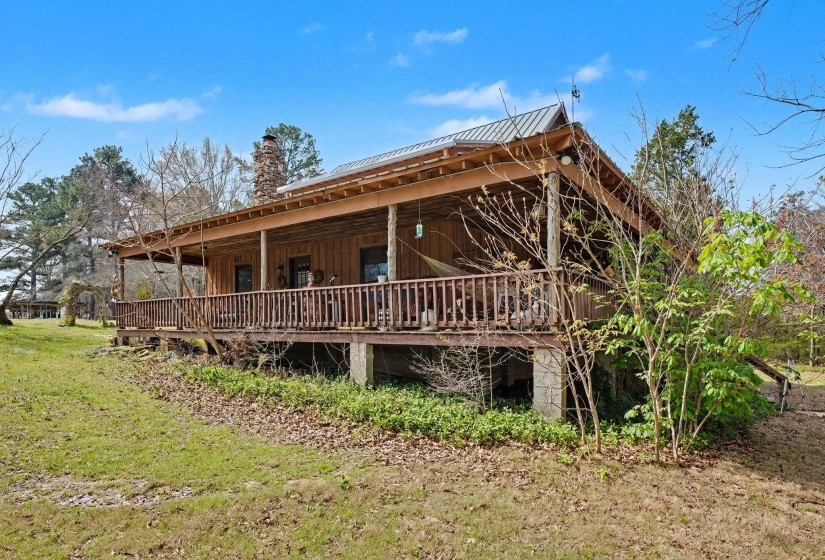 Back of house featuring a metal roof, a chimney, board and batten siding, and a porch