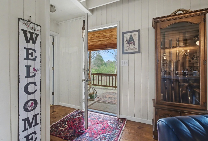 Foyer entrance featuring dark wood-style floors and wooden walls