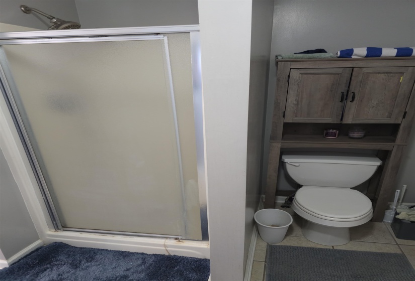 Full bath featuring a shower stall and light tile patterned floors