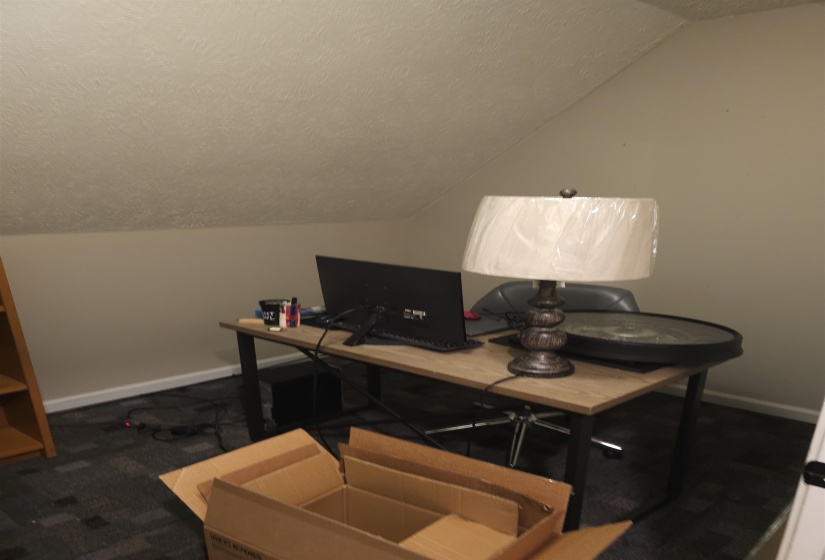 Office with baseboards and dark carpet