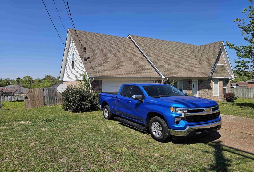 View of side of property with brick siding and a shingled roof