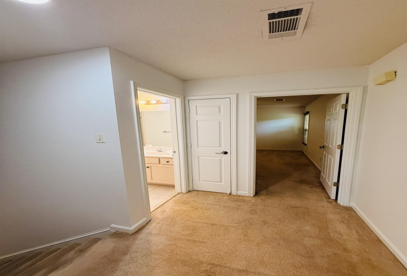 Hallway featuring light colored carpet and baseboards