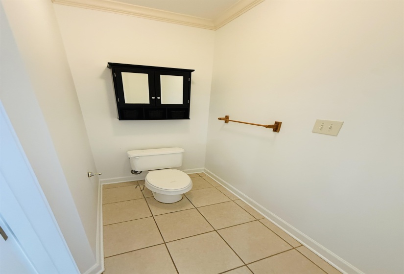 Bathroom featuring crown molding and light tile patterned floors