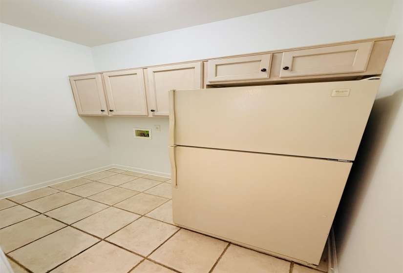 Laundry room with light tile patterned floors, cabinet space, and hookup for a washing machine