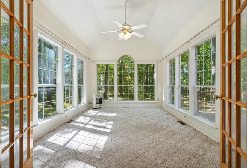 Unfurnished sunroom featuring lofted ceiling, carpet floors, and heating unit