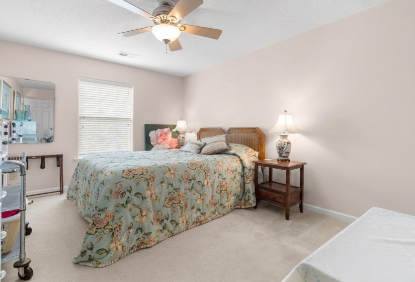 Bedroom with light colored carpet and ceiling fan
