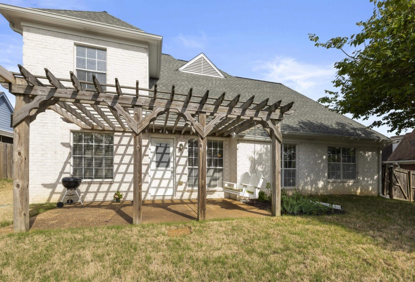 Rear view of house with a pergola, brick siding, a shingled roof, and a patio area