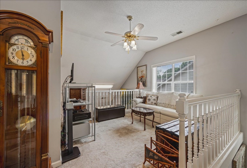 Living room featuring light carpet and a ceiling fan