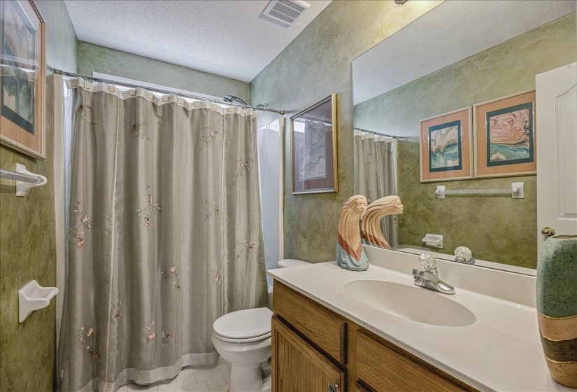 Bathroom featuring vanity, a textured ceiling, a shower with curtain, and light tile patterned floors