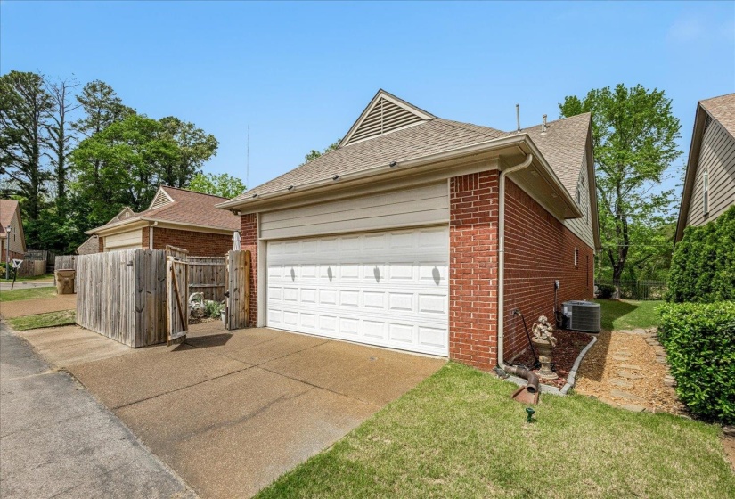 View of home's exterior featuring roof with shingles, brick siding, and driveway