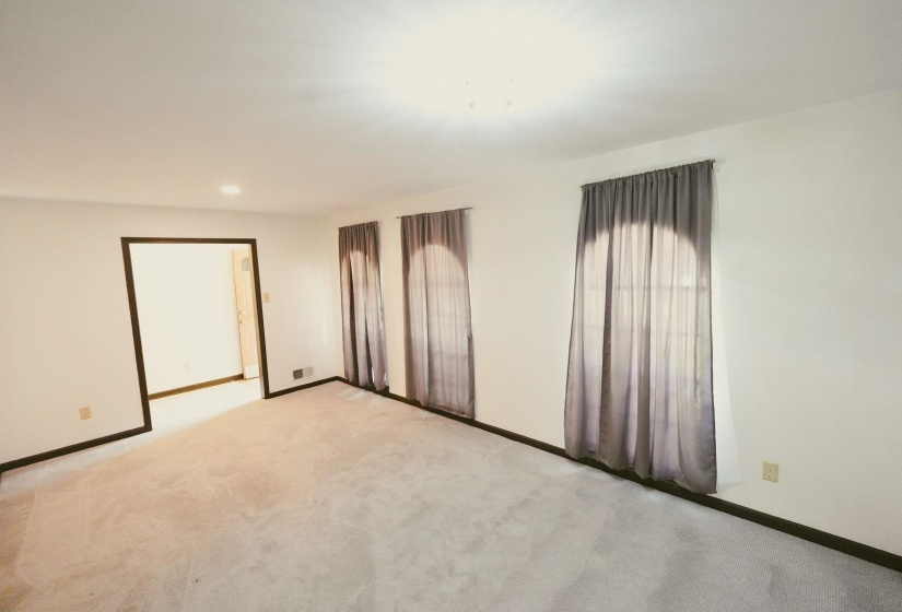 Unfurnished family Den with light carpet and recessed lighting