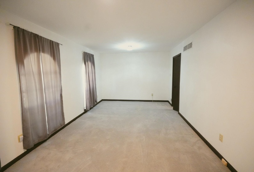 Empty room featuring baseboards and light carpet