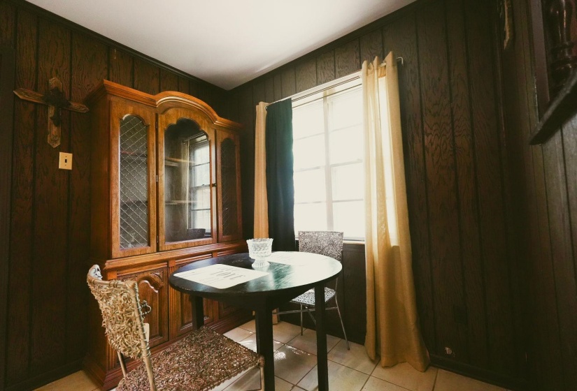Dining area featuring wooden walls and light tile patterned flooring