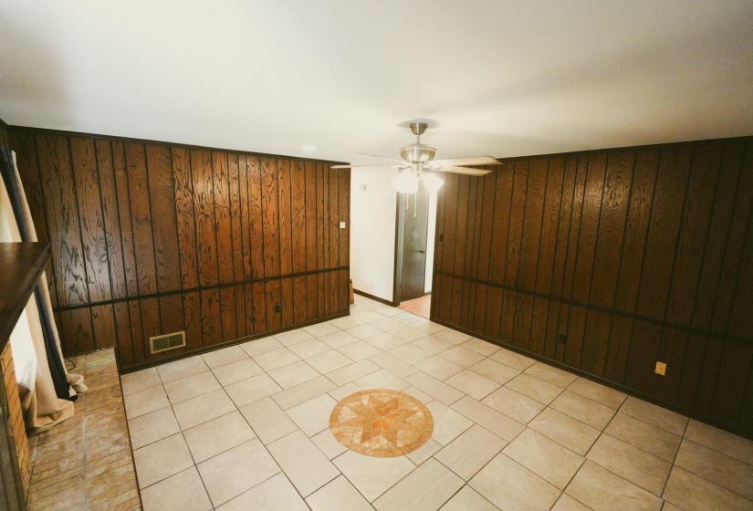 Empty room with wooden walls and a ceiling fan