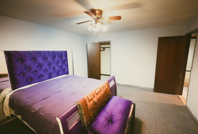 Bedroom featuring light colored carpet, a textured ceiling, and ceiling fan