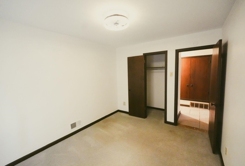 Unfurnished bedroom with light carpet and a closet