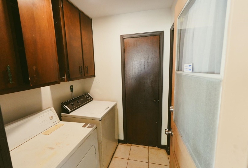 Laundry room featuring cabinet space, light tile patterned flooring, and washer and clothes dryer