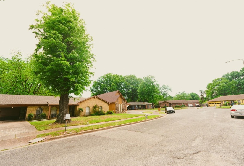 View of asphalt road with sidewalks, curbs, and a residential view