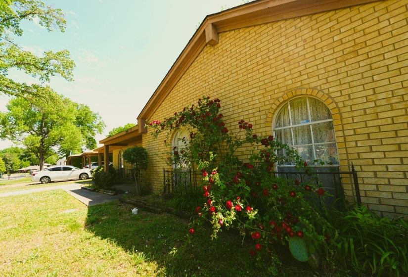 View of property exterior with brick siding and a lawn