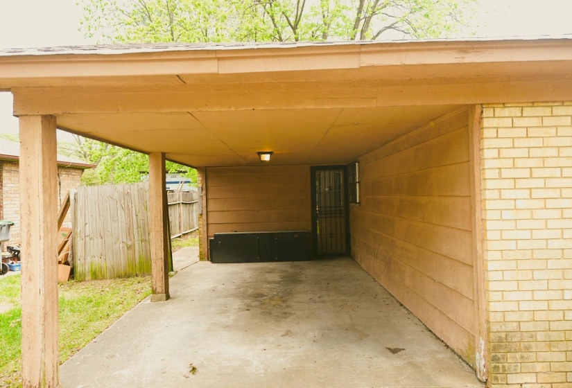 View of parking featuring an attached carport