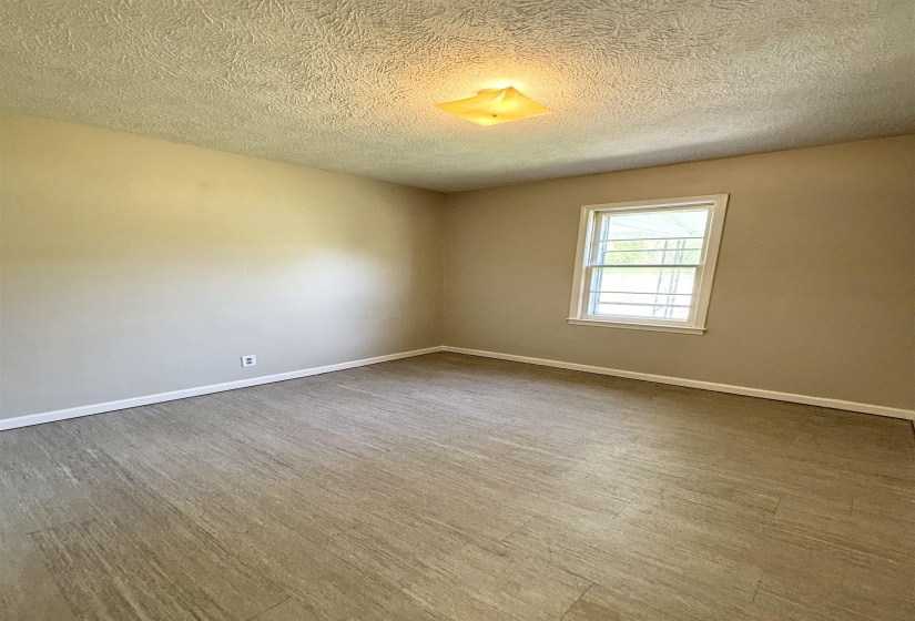 Empty room with a textured ceiling and wood finished floors