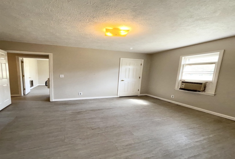 Empty room with a textured ceiling and light wood-style flooring