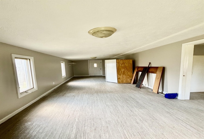 Unfurnished living room with wood finished floors and a textured ceiling