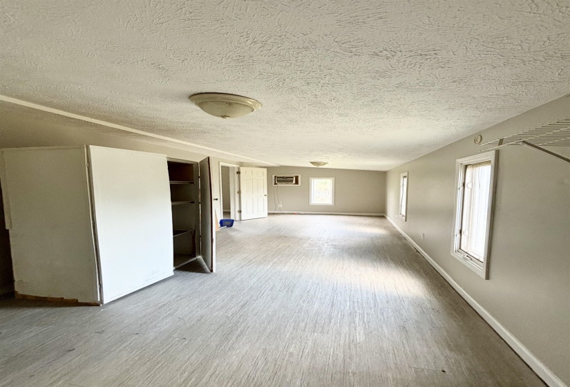Empty room featuring light wood-style floors and a textured ceiling
