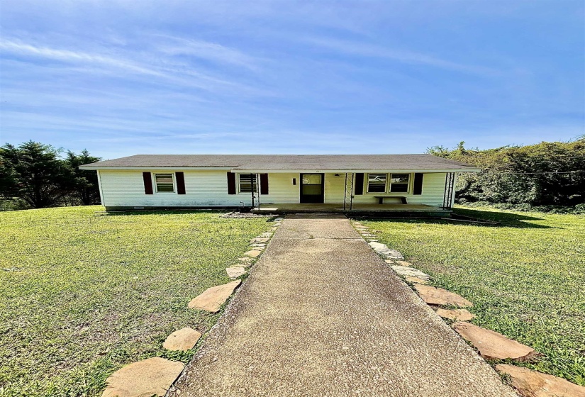 Ranch-style home featuring a porch and a front lawn