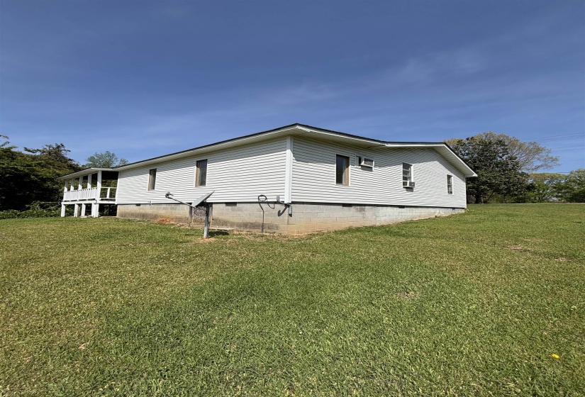 View of home's exterior featuring crawl space and a lawn