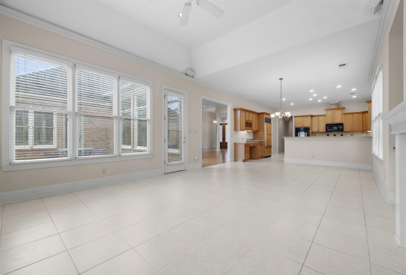 Unfurnished living room with hanging lights, a ceiling fan, light tile patterned flooring, and crown molding