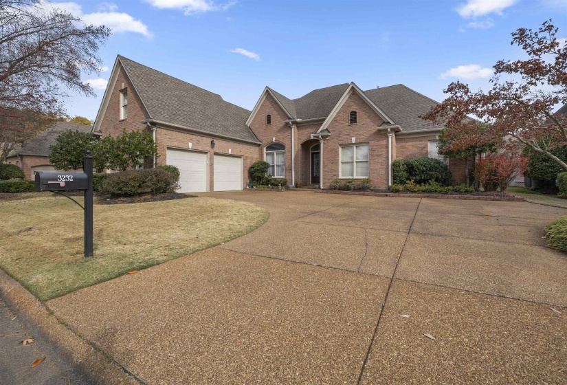 Traditional home with a shingled roof, brick siding, driveway, and a front yard