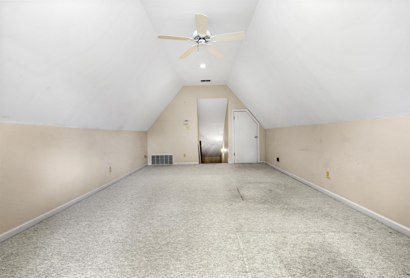Additional living space with carpet floors and a ceiling fan