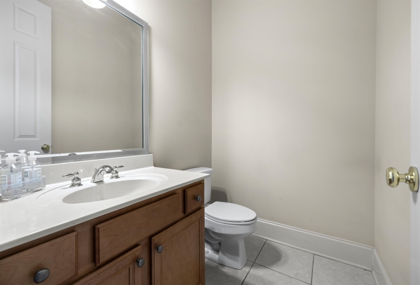 Half bathroom featuring vanity and light tile patterned floors