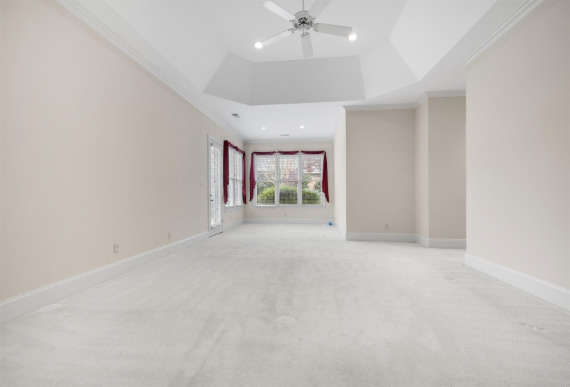 Unfurnished room featuring crown molding, light colored carpet, recessed lighting, a ceiling fan, and a tray ceiling